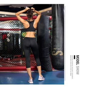 Vue arrière du legging de yoga noir taille haute et de la brassière de sport dans un gymnase