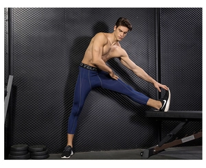 Detail of dark blue compression fitness pants with reinforced grey seams and elastic waistband