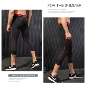 Detail of men's compression tights showing red stitching and elastic waistband in gym