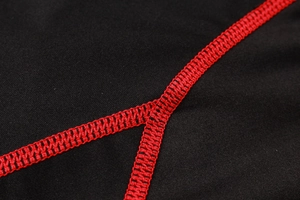 Detail of red flatlock stitching on men's black compression shirt with high elasticity