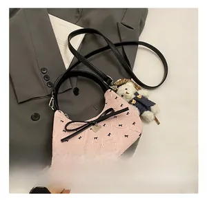 Detailansicht der rosa Halbmondtasche mit schwarzen Schleifen und kleinem Bärenanhänger