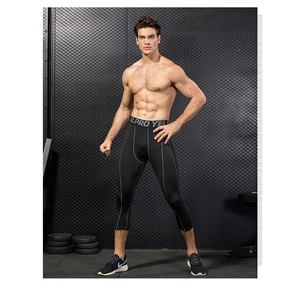 Detail of pro men's 3/4 compression leggings featuring grey contrast stitching and wide waistband