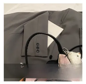 Detail der rosa Tasche mit schwarzer Schleife, rundem Griff und Bärenanhänger
