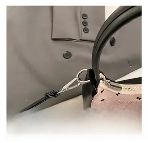 Nahaufnahme der silbernen Metallschließe an der rosa Handtasche mit schwarzen Details