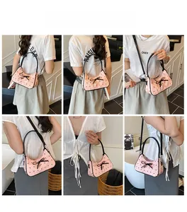 Detail view of pink quilted crossbody bag with black bow and detachable strap