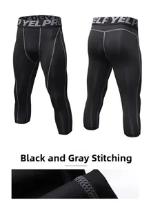 Detail of men's 3/4 compression pants showing black fabric with grey stitching and logo
