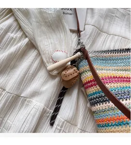 Detail of colorful striped woven tote bag with a vintage baseball theme keychain