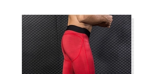 Detail of red compression pants featuring honeycomb texture and black elastic waistband