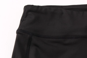 Gros plan détaillé sur la taille haute élastique et les coutures de ce pantalon de yoga noir