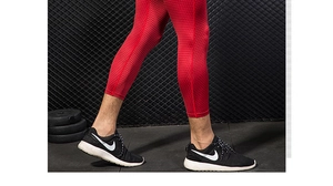 Detail of red compression pants featuring 3D honeycomb texture for high-performance fitness