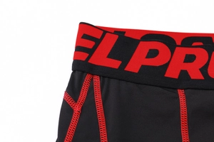 Close-up of men's compression shorts with red elastic waistband and flatlock stitching