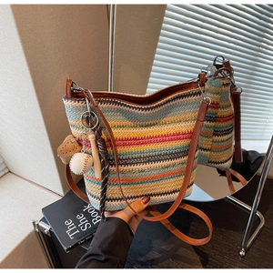Detail of colorful striped woven tote bag with leather strap and baseball charm