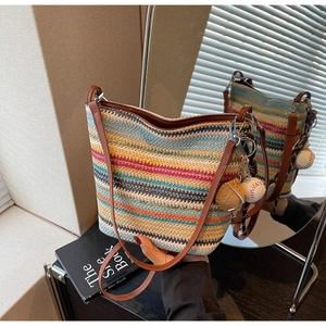 Detail of colorful striped woven tote bag with leather strap and baseball charm