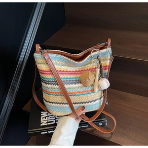Close-up of colorful striped woven tote bag with creative baseball charm detail