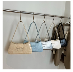 Row of colorful baguette underarm bags with bow detail and glossy embossed leather