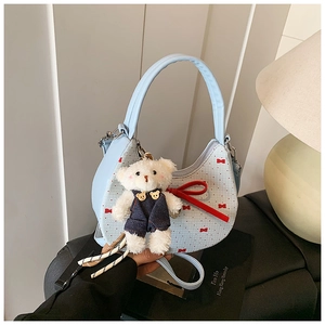 Detailansicht der hellblauen Hobo-Tasche mit roten Schleifen und Bären-Anhänger