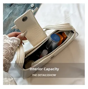 Detail view of the spacious white shoulder bag interior holding personal cosmetics