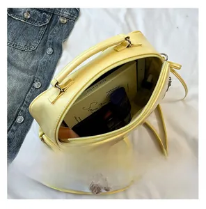 Top view of open yellow PVC bag showing spacious interior with cosmetics and books