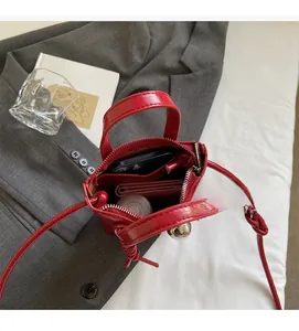 Vista macro dell'interno della borsa rossa lucida con spazio per telefono e portafogli