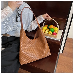 Detail of premium brown woven leather hobo bag showing texture and thick strap