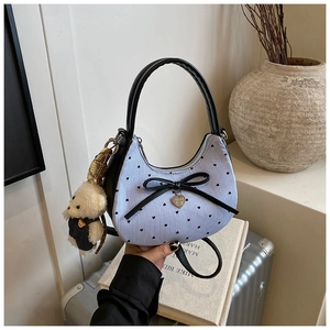 Detailansicht der gestreiften Canvas-Tasche mit Herzmuster und Teddybär-Anhänger