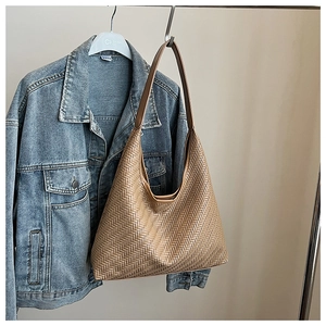 Close-up of light brown woven faux leather pattern on large retro shoulder bucket bag