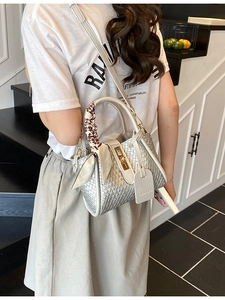Sac seau tissé argenté avec foulard décoratif porté par un mannequin en studio