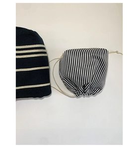 Detailed view of striped canvas drawstring storage bags with black and white patterns