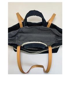 Internal view of large navy denim tote bag with striped lining and leather handles