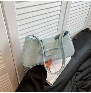 Close-up of light blue wrinkled leather shoulder bag with chic bow detail and slim straps