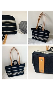 Detail view of striped canvas tote bag with leather handles and drawstring inner pouch