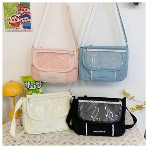 Detailed view of four colorful canvas messenger bags with lace-trimmed transparent PVC windows
