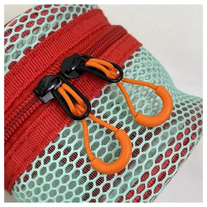 Close-up of contrast-colored mesh laundry bag with dual zippers and orange pull cords