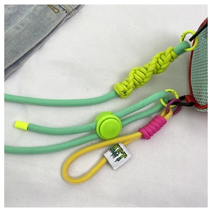 Detail showing vibrant woven rope strap with metal hook and stylish brand tag