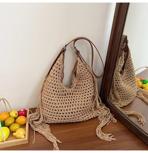 Detail of hand-woven crochet mesh texture and long tassels on a beige tote bag