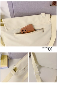 Detail of off-white messenger bag showing back zipper pocket and adjustable strap buckle