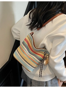 Bohemian striped woven tote bag with brown leather straps and baseball charm shown on model