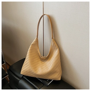 Macro shot of light brown hobo bag featuring detailed woven wheat pattern texture