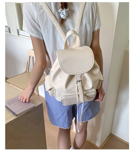 Close-up of soft cream leather backpack showing drawstring closure and buckle details