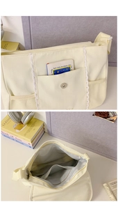 Close-up of cream canvas messenger bag with lace trim and interior storage detail