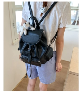 Rear view of black PU leather backpack with magnetic flap and plush bear charm decoration