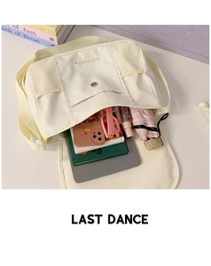 Interior storage of cream canvas messenger bag showing large capacity for daily items