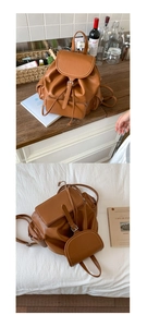 Detail of brown faux leather backpack showing drawstring closure and metal buckle