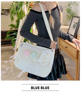Detail of white messenger bag with clear PVC window and cute star and bone plush charms