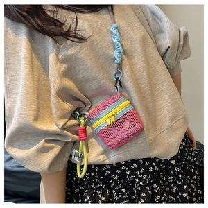 Close-up of pink mesh mini bag with yellow zipper and colorful braided lanyard cord