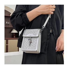 Silver leopard sequin crossbody phone bag worn by a model in a cozy indoor setting