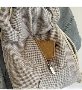 Detail of oatmeal waffle texture backpack with vertical zipper pocket and drawstring