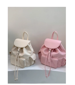 Detail view of cream and light pink PU leather backpacks with drawstring closure
