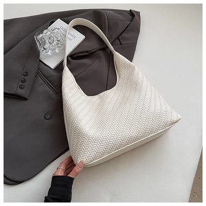 Close-up of white woven leather hobo bag with a wide strap and premium texture
