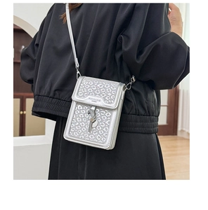 Close-up of a silver leopard print sequin crossbody bag with knot tassel detail